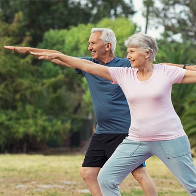 Old couple doing yoga in the sun