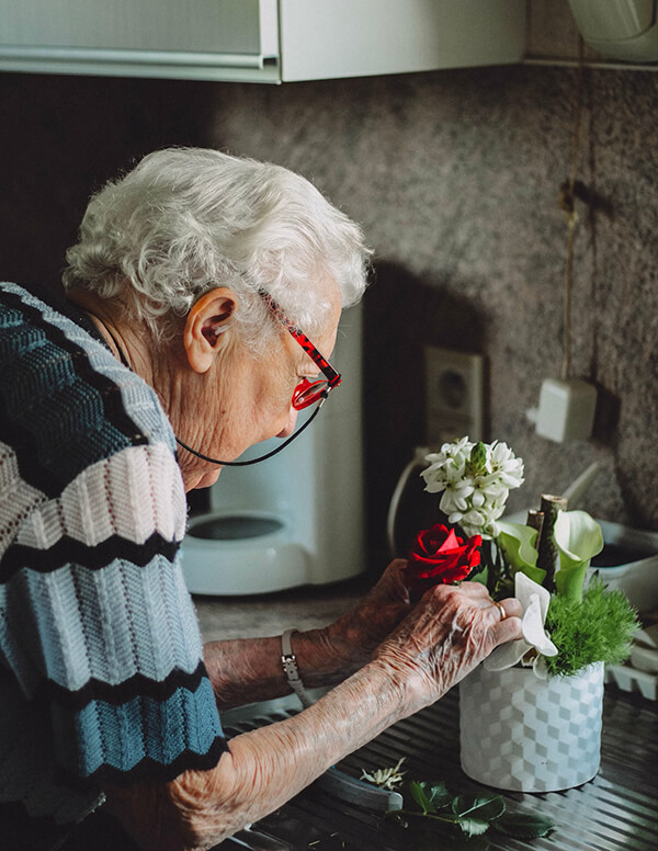 Elderly Woman Flowers Kitchen