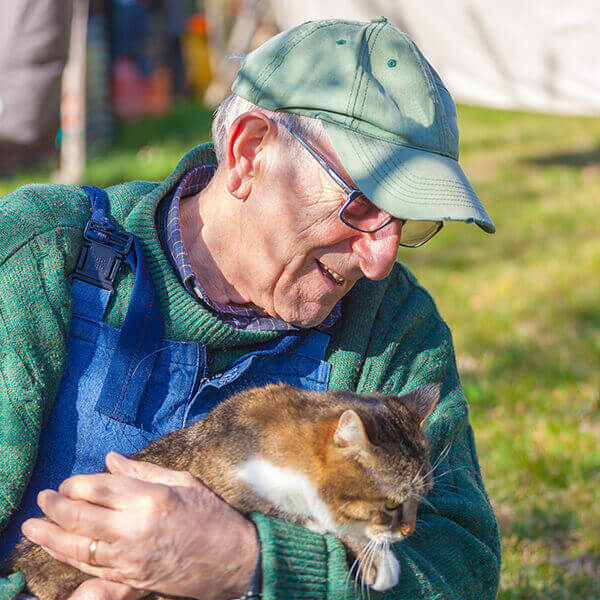 Elderly man with his pet cat smiling
