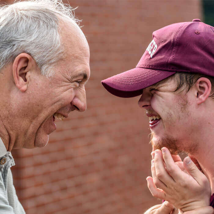 Disabled Person Laughing With Senior Friend