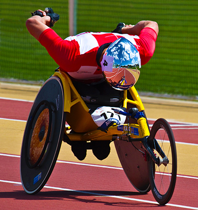 Wheelchair Athelete Running - Wheelchair Racing on Paralympic Track in Aerodynamic Position