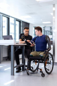 Two men using a PC one is an amputee