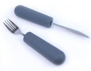 Knife and fork with thick gray ergonomic handles designed to assist individuals with limited grip strength.